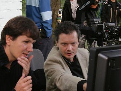 Two men looking at a screen in front of professional camera equipment