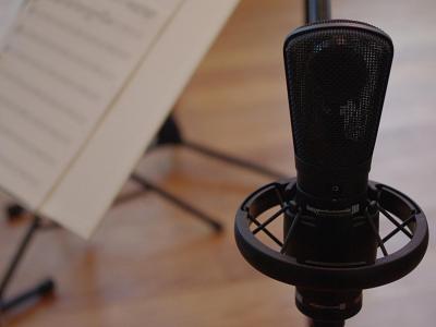 Close up of professional microphone with sheet music behind it