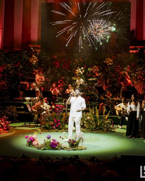 Berklee Valencia vocalist performing on a stage filled with flower arrangements